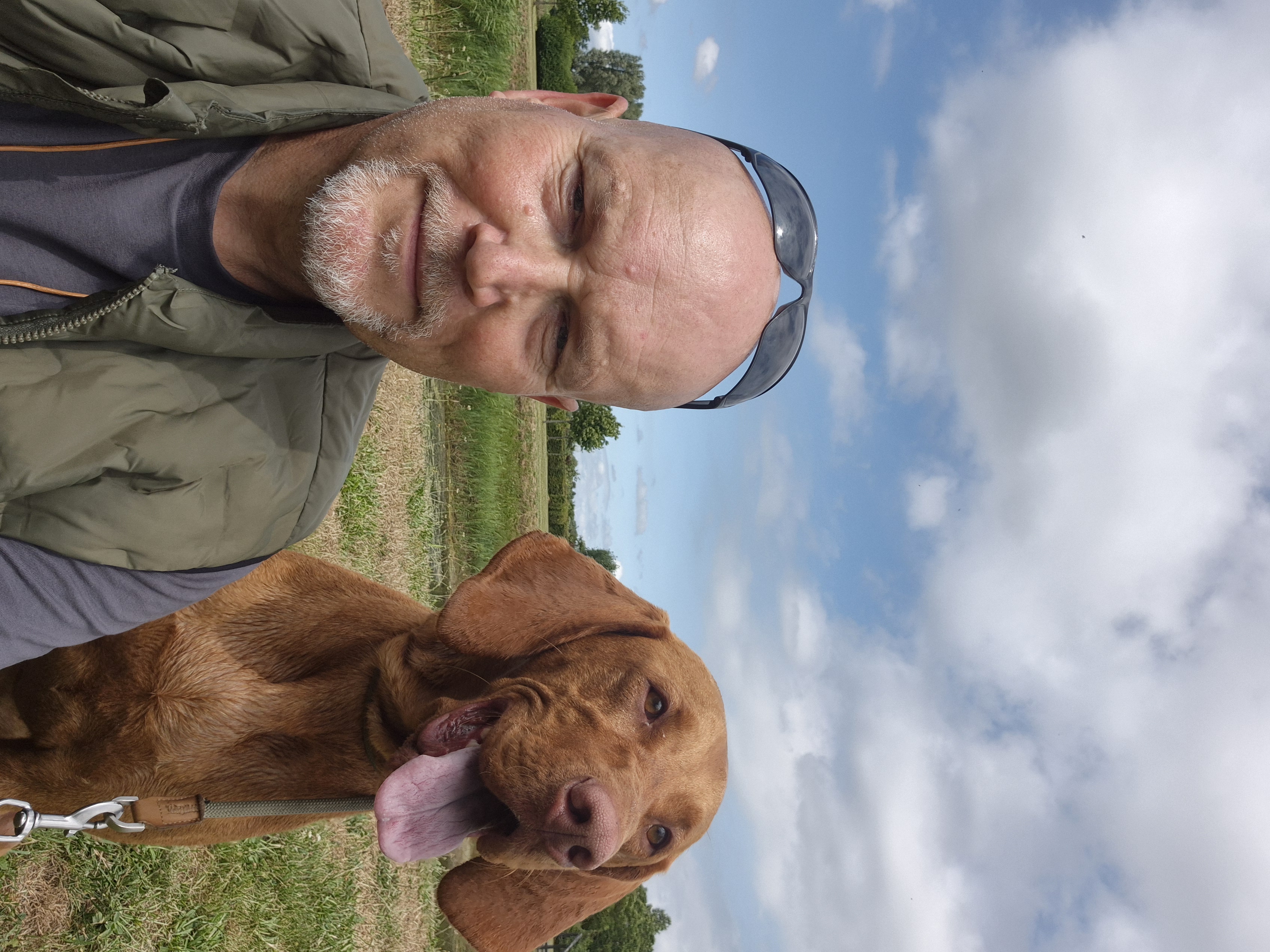 Hans Krijger with hands gently placed on the head of a dark horse in an indoor stable setting