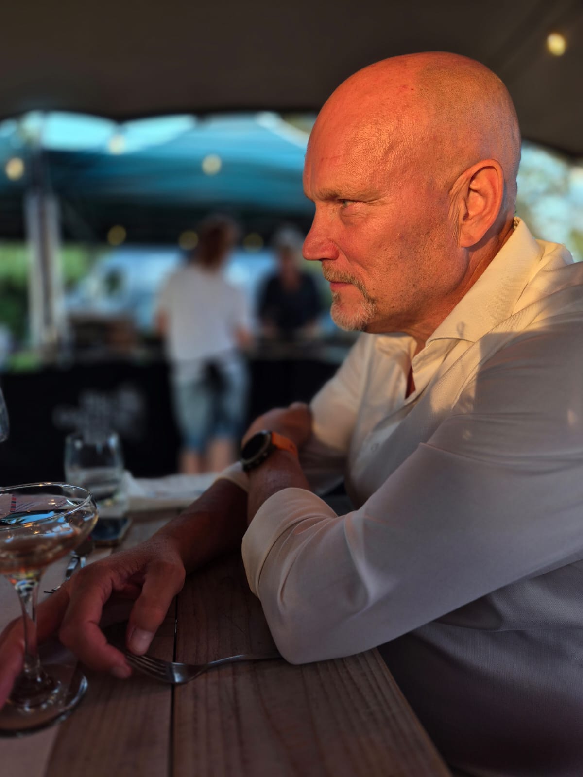 Hans Krijger with long blonde hair, wearing a light blue polo shirt, touching the back of a dark horse